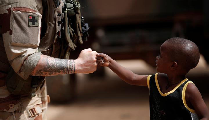 seorang tentara perancis menyapa seorang anak saat tentara melakukan patroli CIMIC (Civil-Military Co-operation) selama Operas Barkel regional anti-pemberontakan di Gao, Mali. (Tempo)